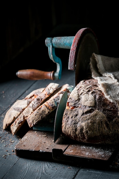 Primo piano del pane sull'affettatrice con le briciole e la farina