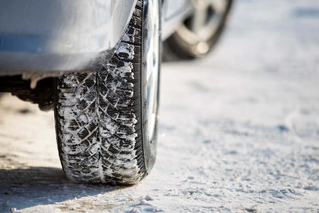 Primo piano del pneumatico di gomma delle ruote dell'auto nella neve profonda. Trasporto e concetto di sicurezza.