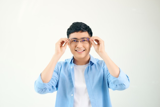 Primo piano del ragazzo amichevole con gli occhiali. Giovane uomo asiatico regolando gli occhiali e fissando attraverso la lente. Concetto di visione e cura degli occhi