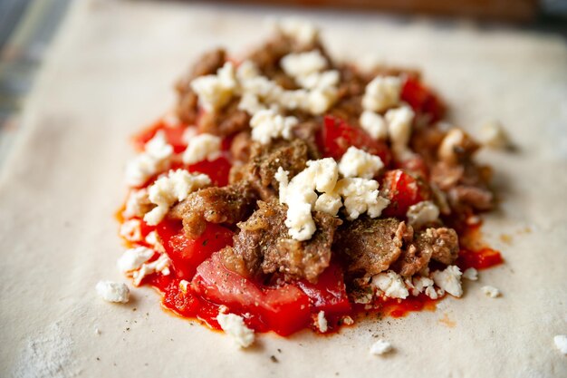 Primo piano del ripieno di pomodoro con formaggio di carne e salsa di peperoncino rosso con spezie per burritos