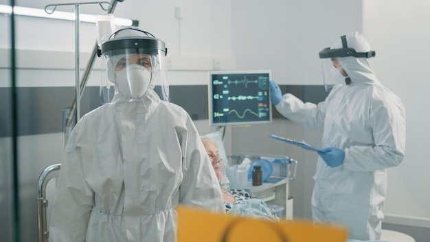 Primo piano del segnale di pericolo nella zona di quarantena del coronavirus. Simbolo sul vetro per l'epidemia di virus infettivo nel reparto ospedaliero, paramedici che cercano di curare il paziente in blocco per la sicurezza sanitaria.