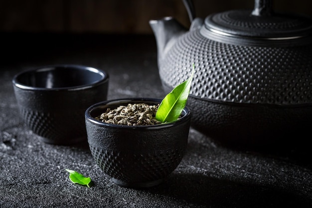 Primo piano del tè verde con la teiera e la tazza