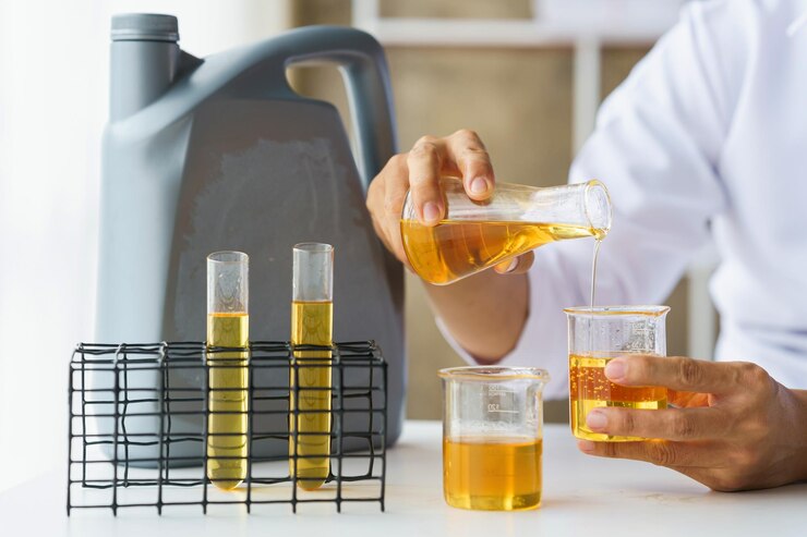 Primo piano del test del lavoratore sul giro e versa il test di qualità dell'olio del motore dell'auto controllando e confrontando la differenza di colore