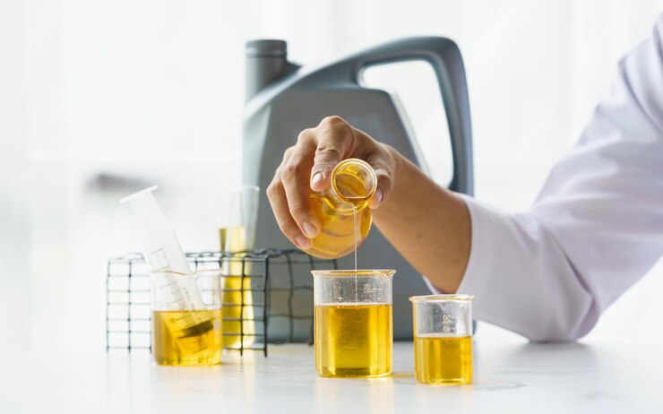 Primo piano del test del lavoratore sul giro e versa il test di qualità dell'olio del motore dell'auto controllando e confrontando la differenza di colore