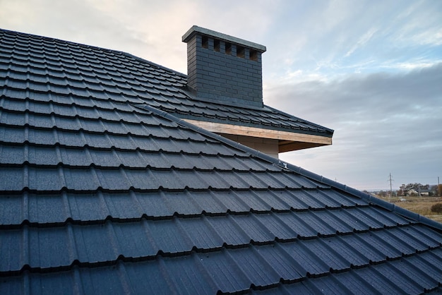 Primo piano del tetto della casa coperto di scandole metalliche.Copertura piastrellata dell'edificio