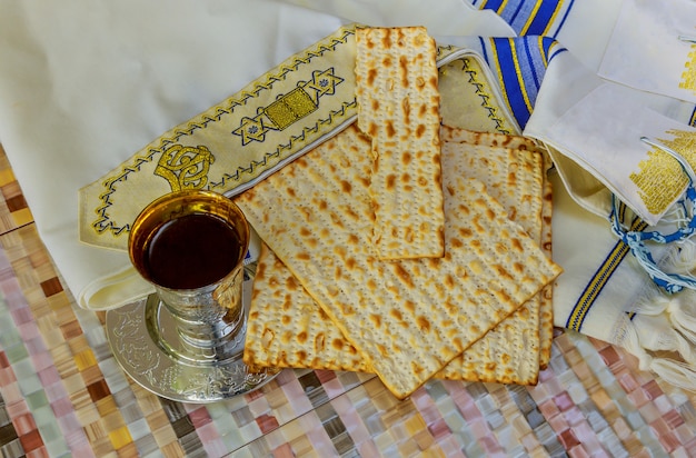 Primo piano del vino e del matzah di vetro di Passover. Struttura vaga retroilluminata del matzah nella priorità bassa.