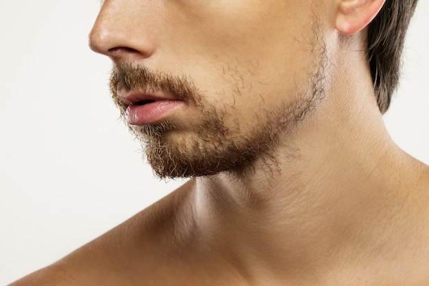 Primo piano del viso maschile non rasato con la barba incoltat