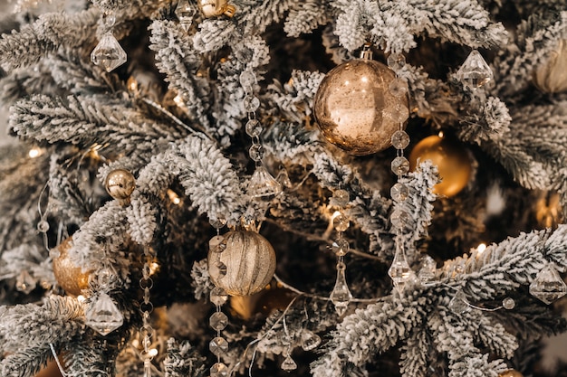 Primo piano dell'albero di Natale. Alla vigilia di Capodanno, un albero di Natale decorato innevato.