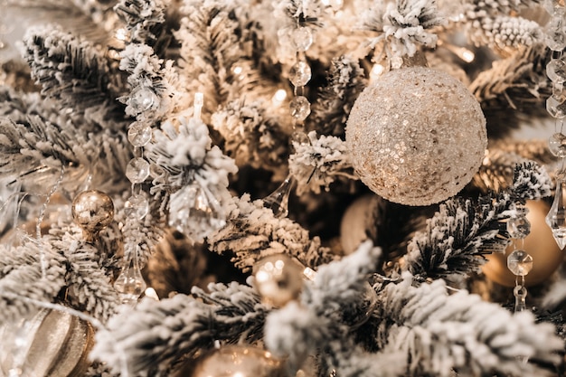 Primo piano dell'albero di Natale. Alla vigilia di Capodanno, un albero di Natale decorato innevato.