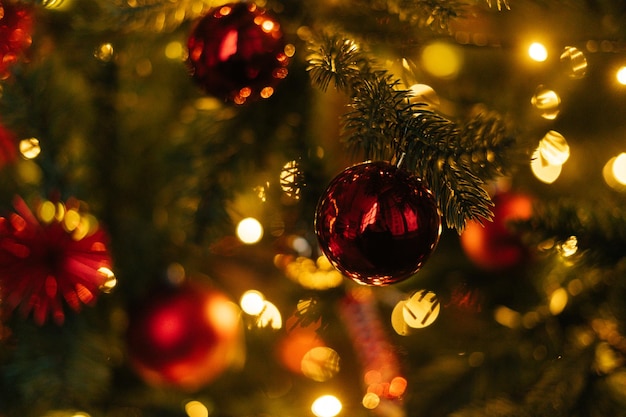 Primo piano dell'albero di Natale decorato a festa con palline rosse luminose su sfondo sfocato fata scintillante Luci sfocate a ghirlanda nel soggiorno