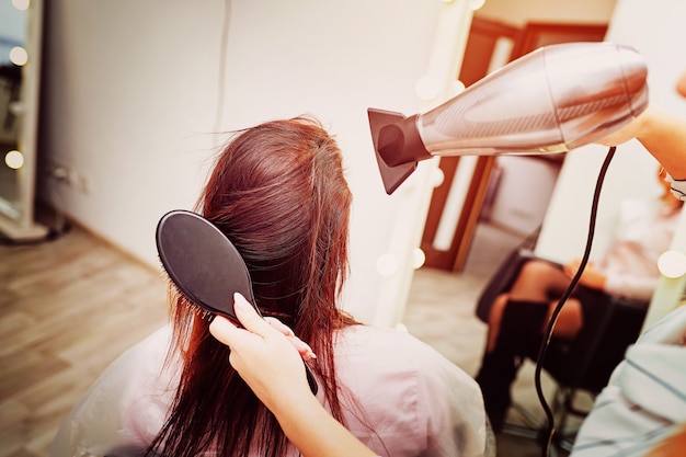 Primo piano dell'asciugacapelli per l'asciugatura dei capelli, parrucchiere concept, stilista femminile.