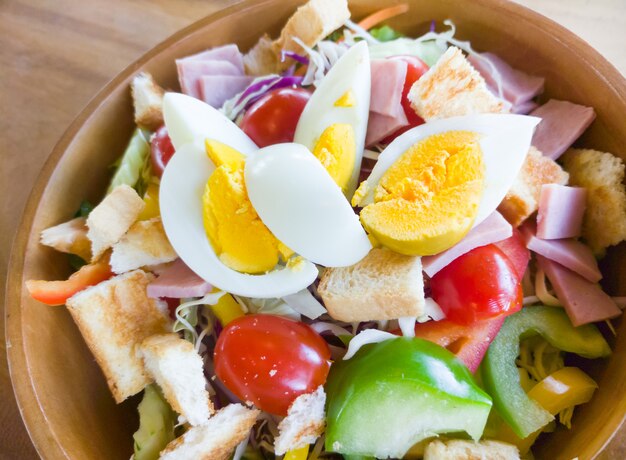 Primo piano dell'insalata organica fresca con il prosciutto e l'uovo sodo.