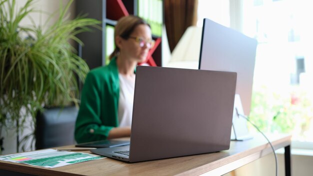 Primo piano dell'interno del posto di lavoro dell'ufficio con la tecnologia moderna del computer portatile e del pc per il concetto di lavoro