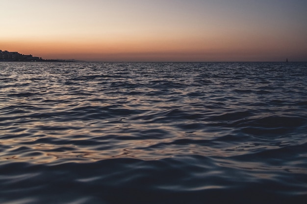 Primo piano dell'onda del mare, inquadratura dal basso, colpo di sole.