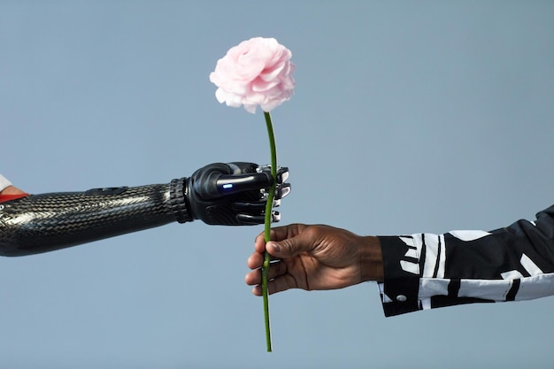 Primo piano dell'uomo africano che dà fiore alla donna con il braccio protesico isolato su priorità bassa blu