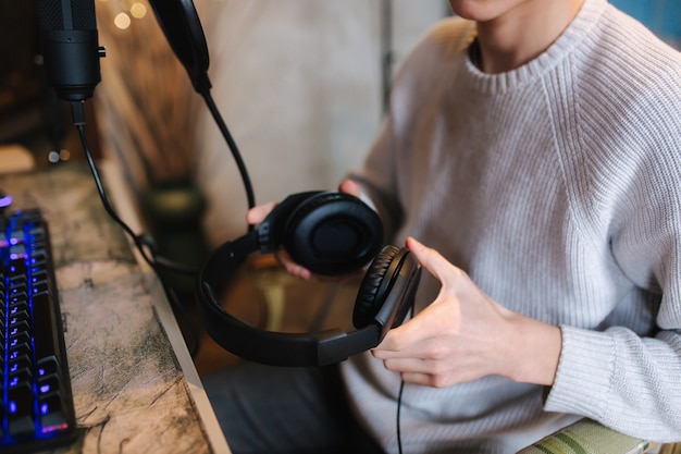 Primo piano dell'uomo che indossa le cuffie durante il lavoro con la musica a casa