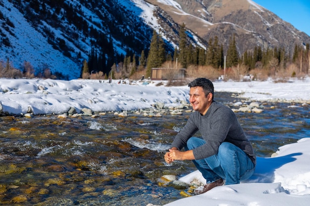 Primo piano dell'uomo che si lava il viso con l'acqua del fiume