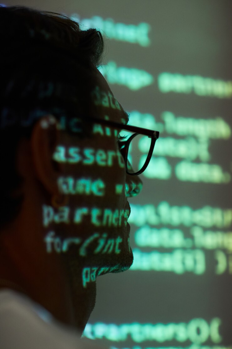 Foto primo piano dell'uomo con gli occhiali seduto alla presentazione del nuovo software in un ufficio buio