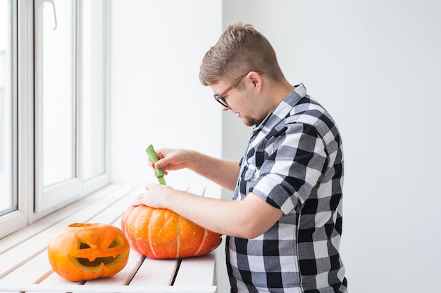 Primo piano dell'uomo con le zucche che si preparano ad Halloween