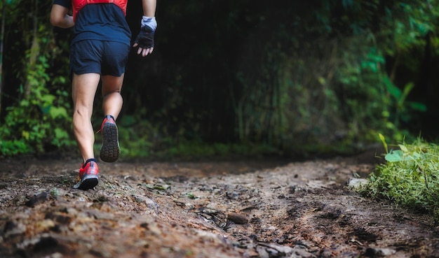 Primo piano dell'uomo trail running su terreno roccioso. Primo piano dei piedi maschili corrono attraverso il terreno roccioso. Concentrati sulle scarpe.