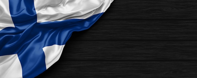 Primo piano della bandiera degli Stati Uniti di Finlandia sullo sfondo di legno nero 3d render
