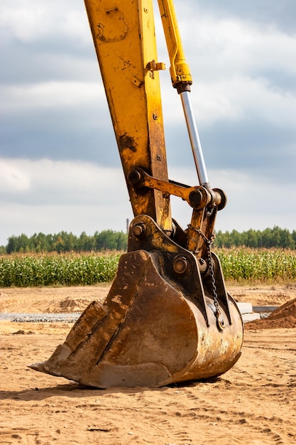 Primo piano della benna dell'escavatore in cantiere Attrezzature da costruzione per lavori di sterro