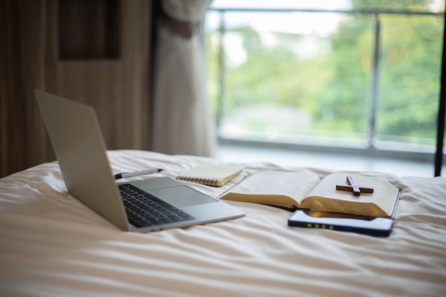 Primo piano della Bibbia e croce di legno. Studia la Bibbia con il culto online.