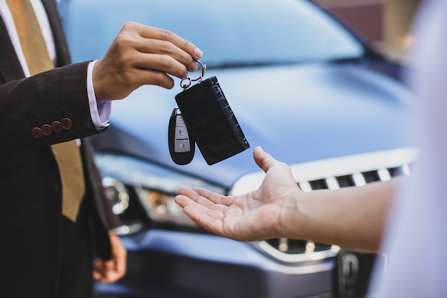 Primo piano della consegna delle chiavi dell'auto dalla vendita dell'auto al proprietario