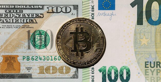 Primo piano della criptovaluta digitale oro bitcoin sdraiato sulla differenza di banconote in dollari e euro