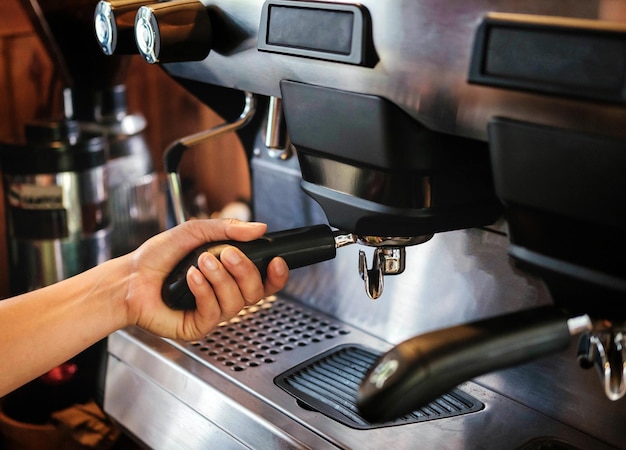 Primo piano della dimensione della bandiera del barista che lavora a fare il caffè con la macchina per il caffè