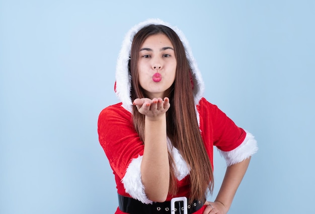 Primo piano della donna caucasica che indossa abiti da Babbo Natale che soffia bacio