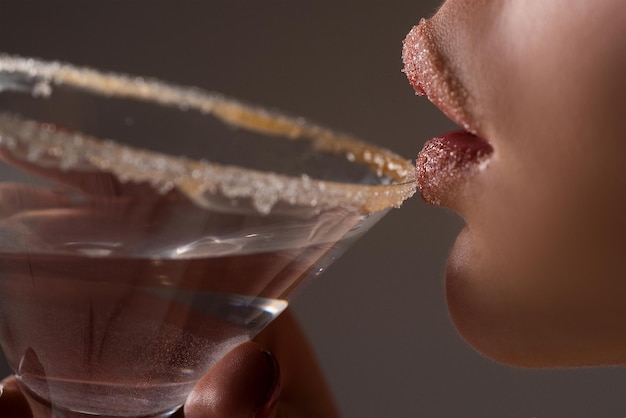 Primo piano della donna che beve Martini. Ragazza del cocktail. Festa dell'alcol.