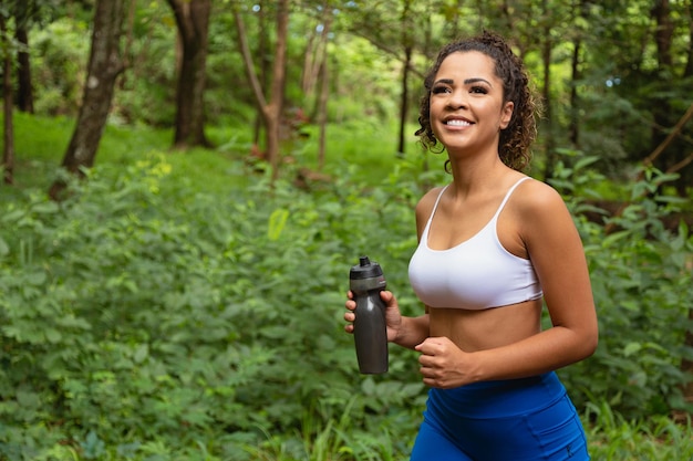 Primo piano della donna che corre nel parco acqua potabile