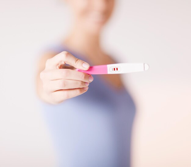 primo piano della donna che tiene il test di gravidanza