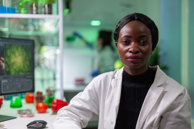 Primo piano della donna del biologo africano che esamina la macchina fotografica?