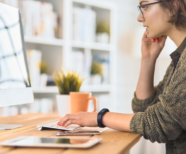 Primo piano della donna di affari che scrive sul computer portatile