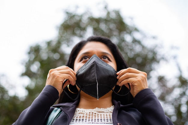 Primo piano della donna di affari latina che indossa una maschera per motivi protettivi durante la pandemia covid