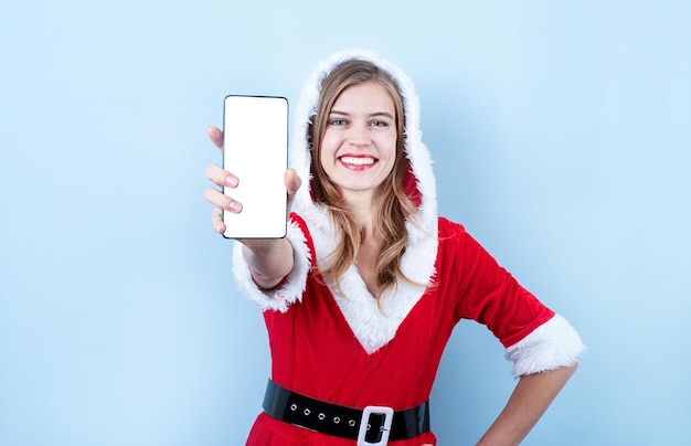 Primo piano della donna felice caucasica che indossa abiti da Babbo Natale che puntano verso lo smartphone