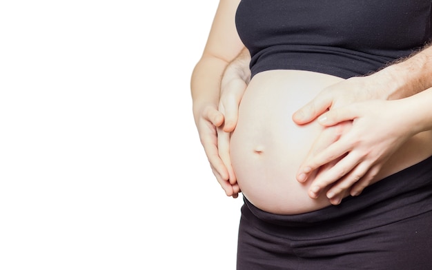 Primo piano della donna incinta che tocca la sua pancia con le mani e anche suo marito, isolato su sfondo bianco