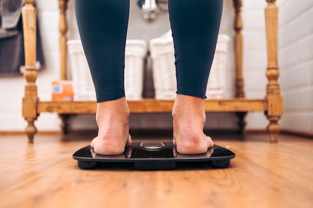 Primo piano della donna su una bilancia da bagno. Concetto di problemi di dieta