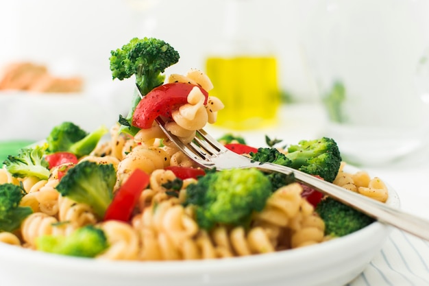 Primo piano della forcella con i broccoli; pomodoro e fusilli in zolla bianca