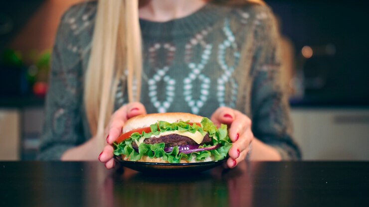 Foto primo piano della giovane donna che preferisce l'hamburger attraente giovane donna che sceglie di mangiare un hamburger sano ...