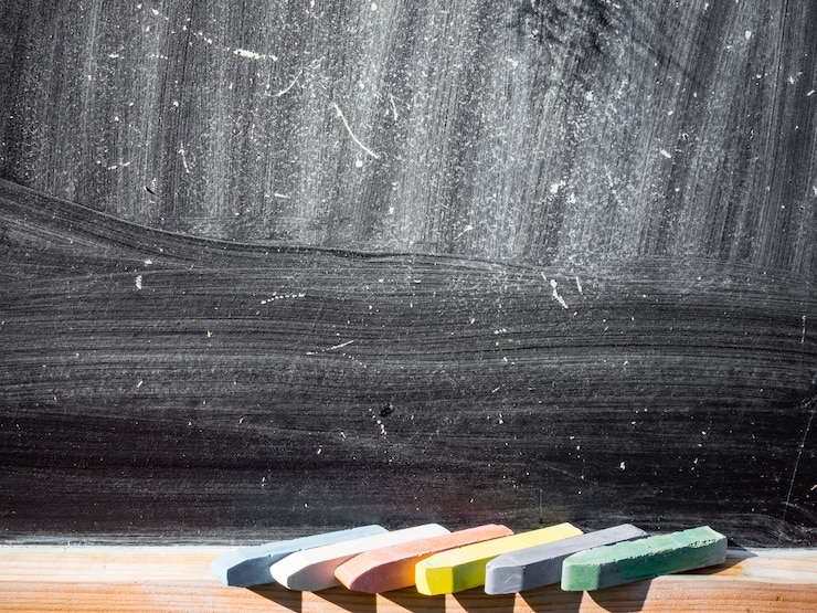 Foto primo piano della lavagna con pezzi di pastelli colorati