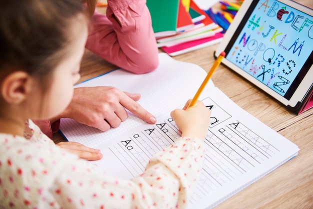 Primo piano della madre che aiuta il figlio a fare i compiti