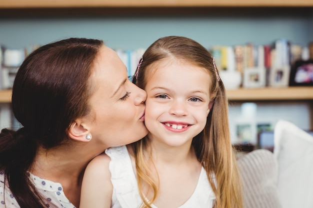 Primo piano della madre che bacia figlia felice