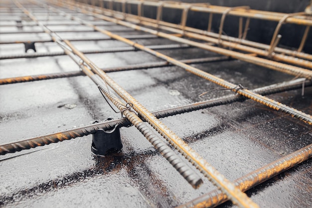 Primo piano della maglia del tondo per cemento armato in acciaio Barre di rinforzo in cantiere Barre di rinforzo in acciaio arrugginito per fondamenta o soffitti in calcestruzzo Processo di costruzione della casa