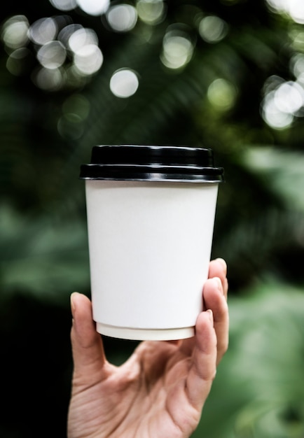 Primo piano della mano che tiene la tazza di carta