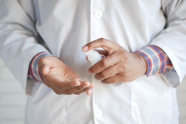 Primo piano della mano del medico con spray igienizzante