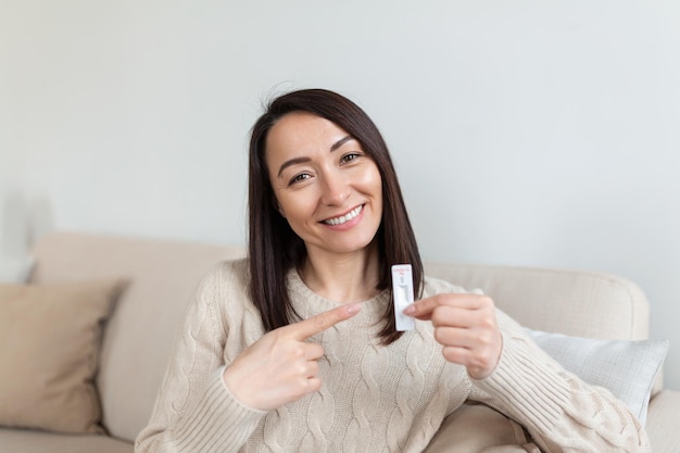 Primo piano della mano della donna che tiene un dispositivo di test negativo Donna asiatica felice che mostra il suo test rapido negativo Coronavirus Covid19 Coronavirus