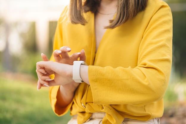 Primo piano della mano della donna con lo smartwatch che controlla la notifica in arrivo sul display a scorrimento dell'orologio intelligente